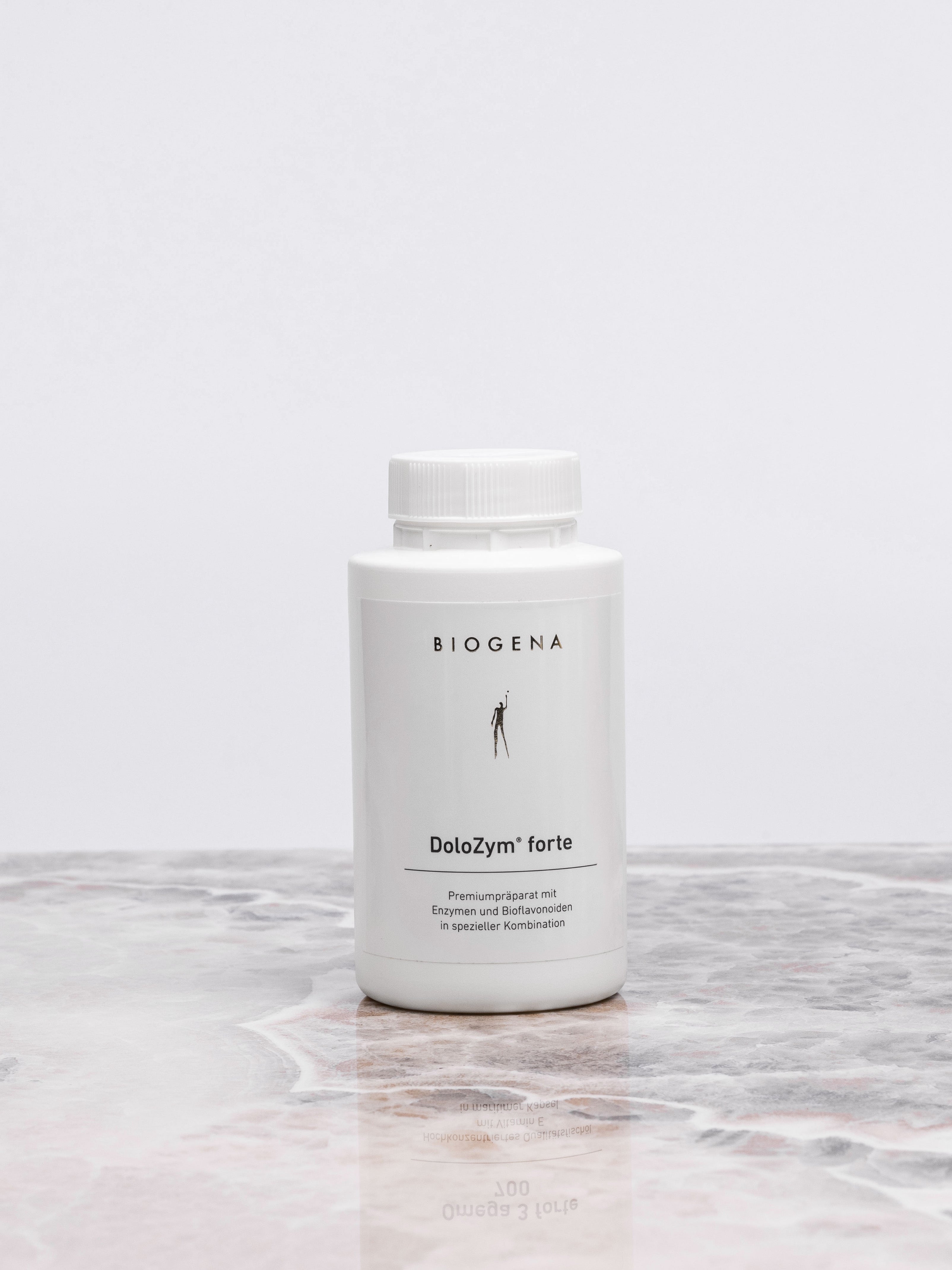 Geschlossene Verpackungsdose Biogena DoloZym forte steht auf einer Marmorplatte.