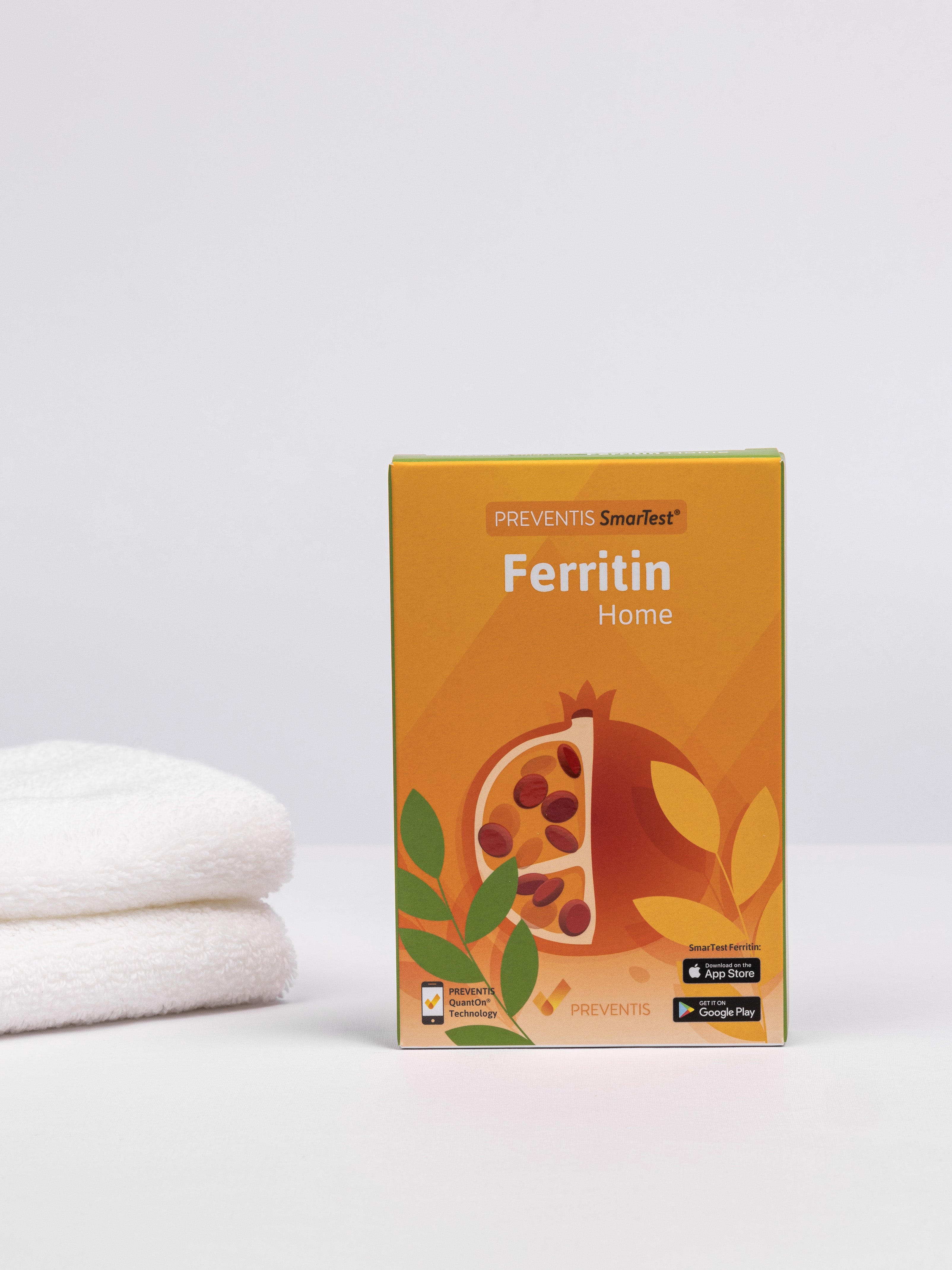 Ferritin Schnelltest Verpackung daneben ein Stapel weiße Handtücher.