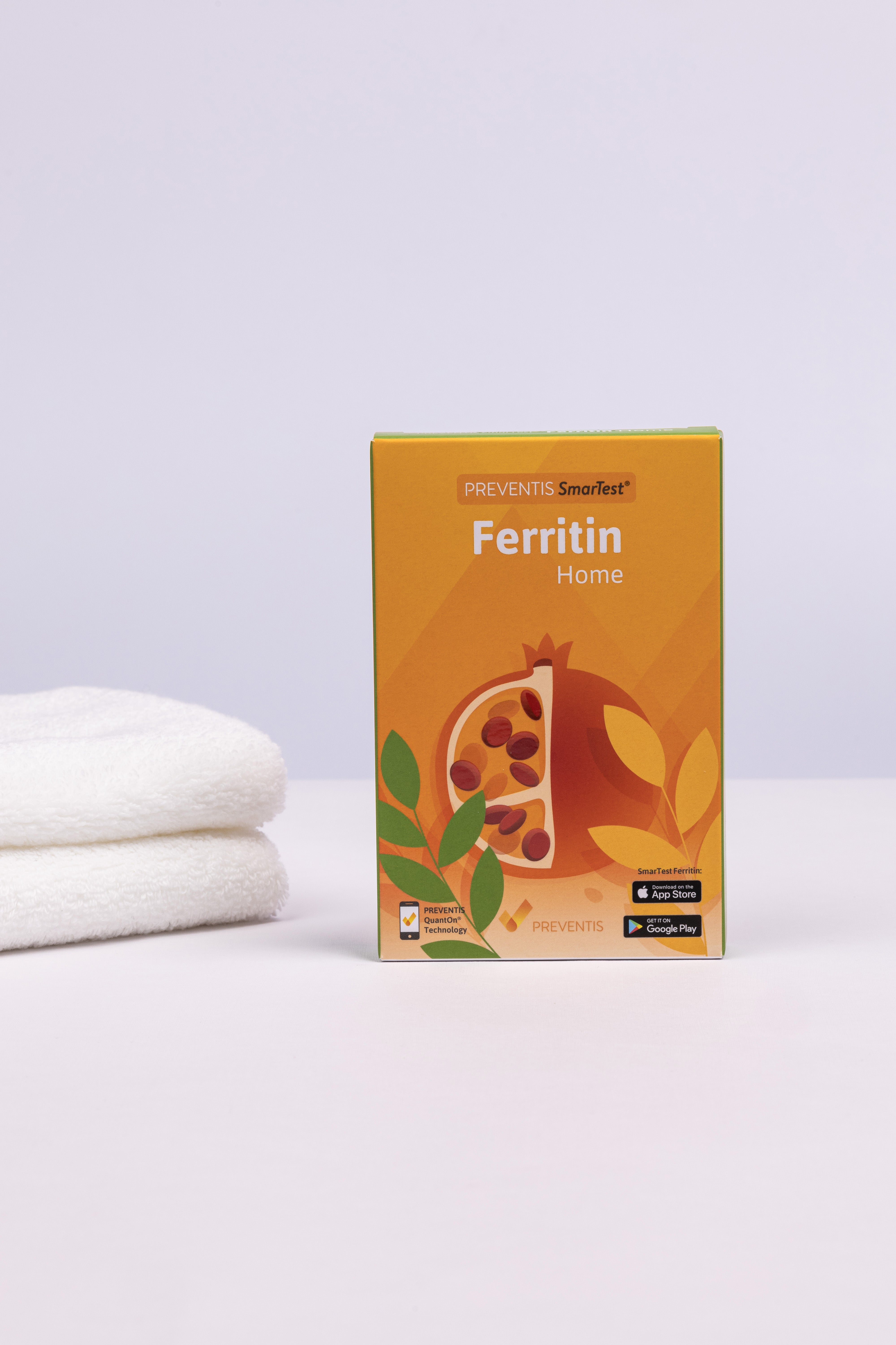 Ferritin Schnelltest Verpackung daneben ein Stapel weiße Handtücher.