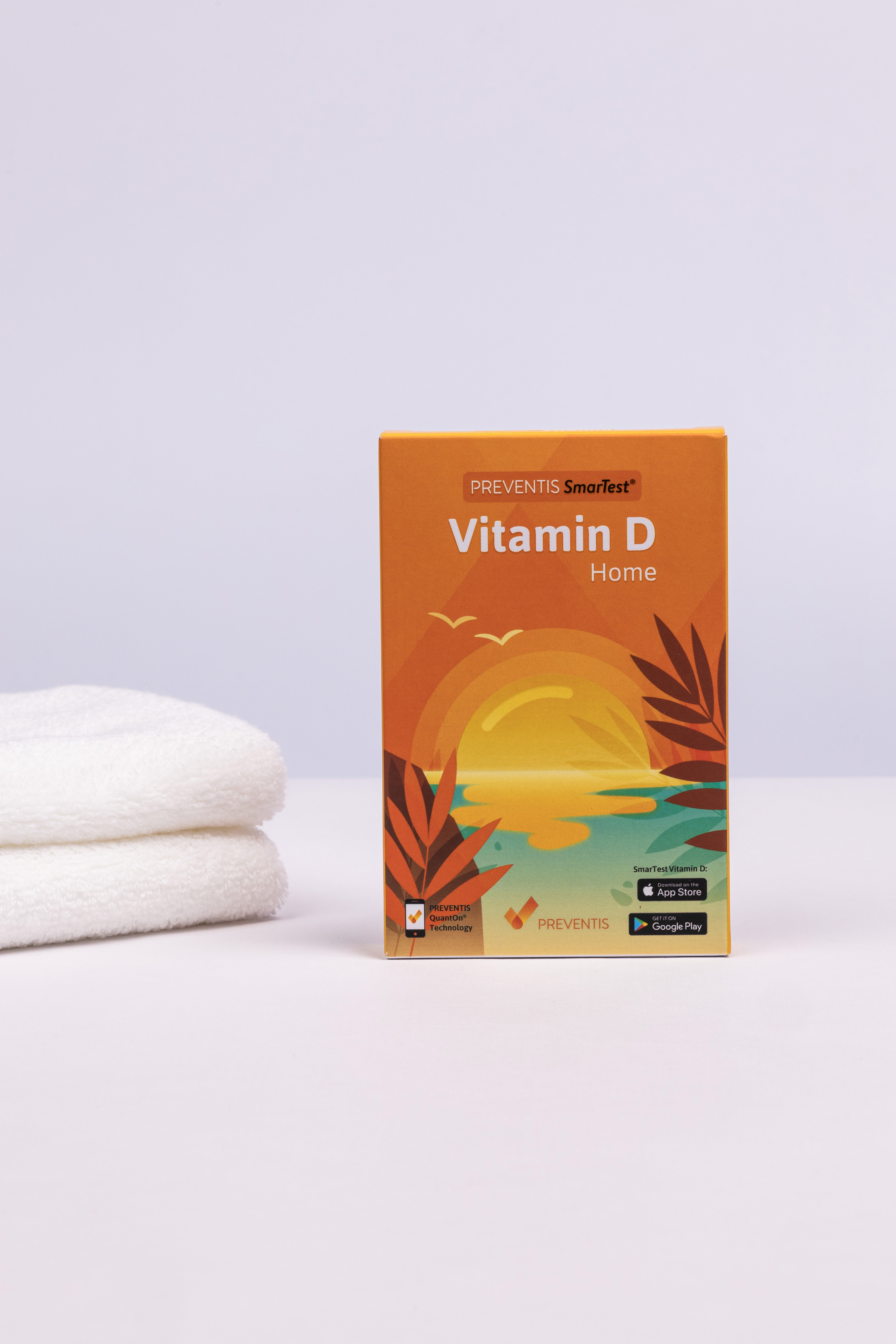 Vitamin D Schnelltest Verpackung links daneben ein Stapel weiße Handtücher.