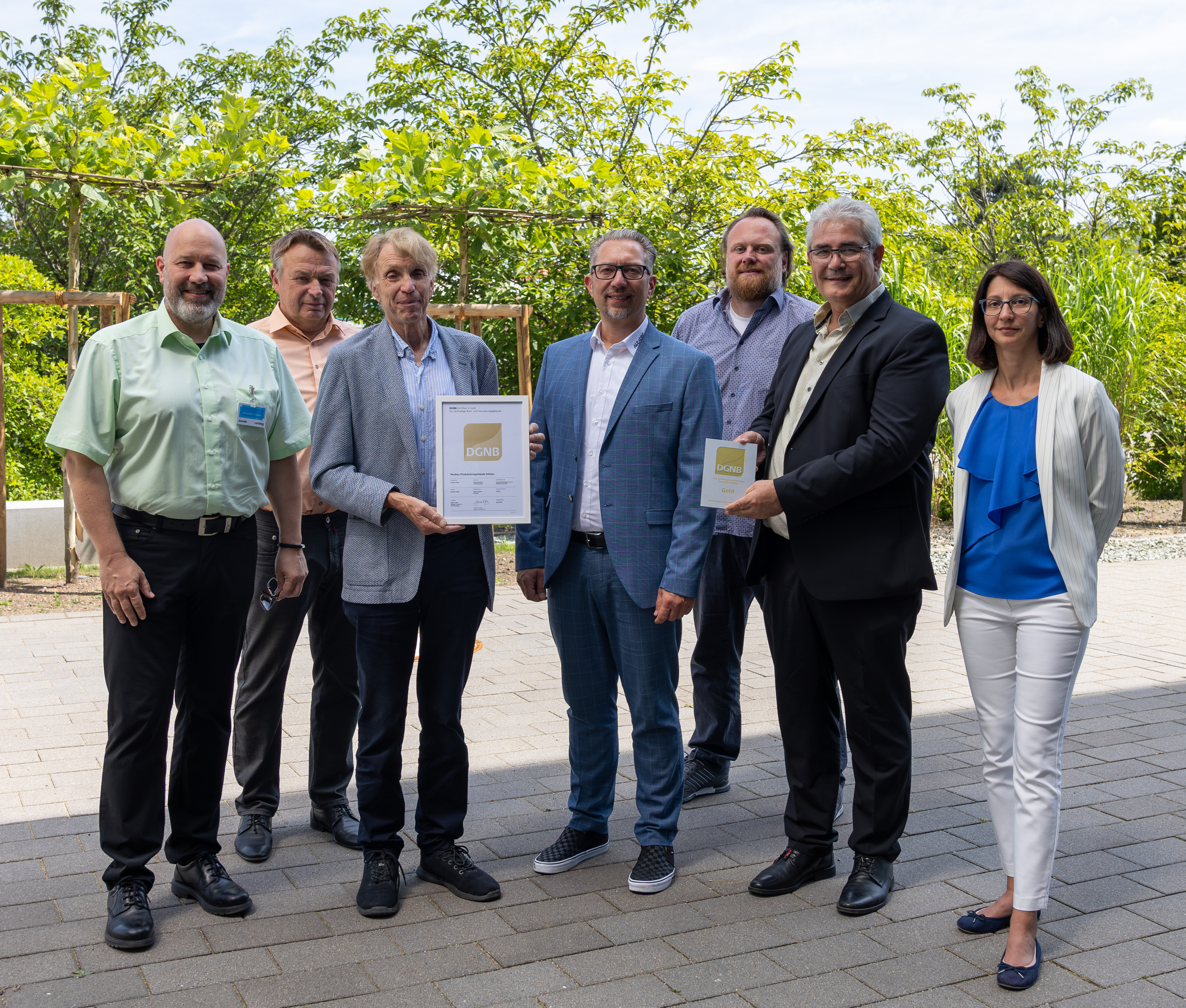 Gruppenbild von Personen unter anderem der Firma Camlog und Altatec, dabei wird stolz das DGNB Zertifikat in den Händen gehalten.
