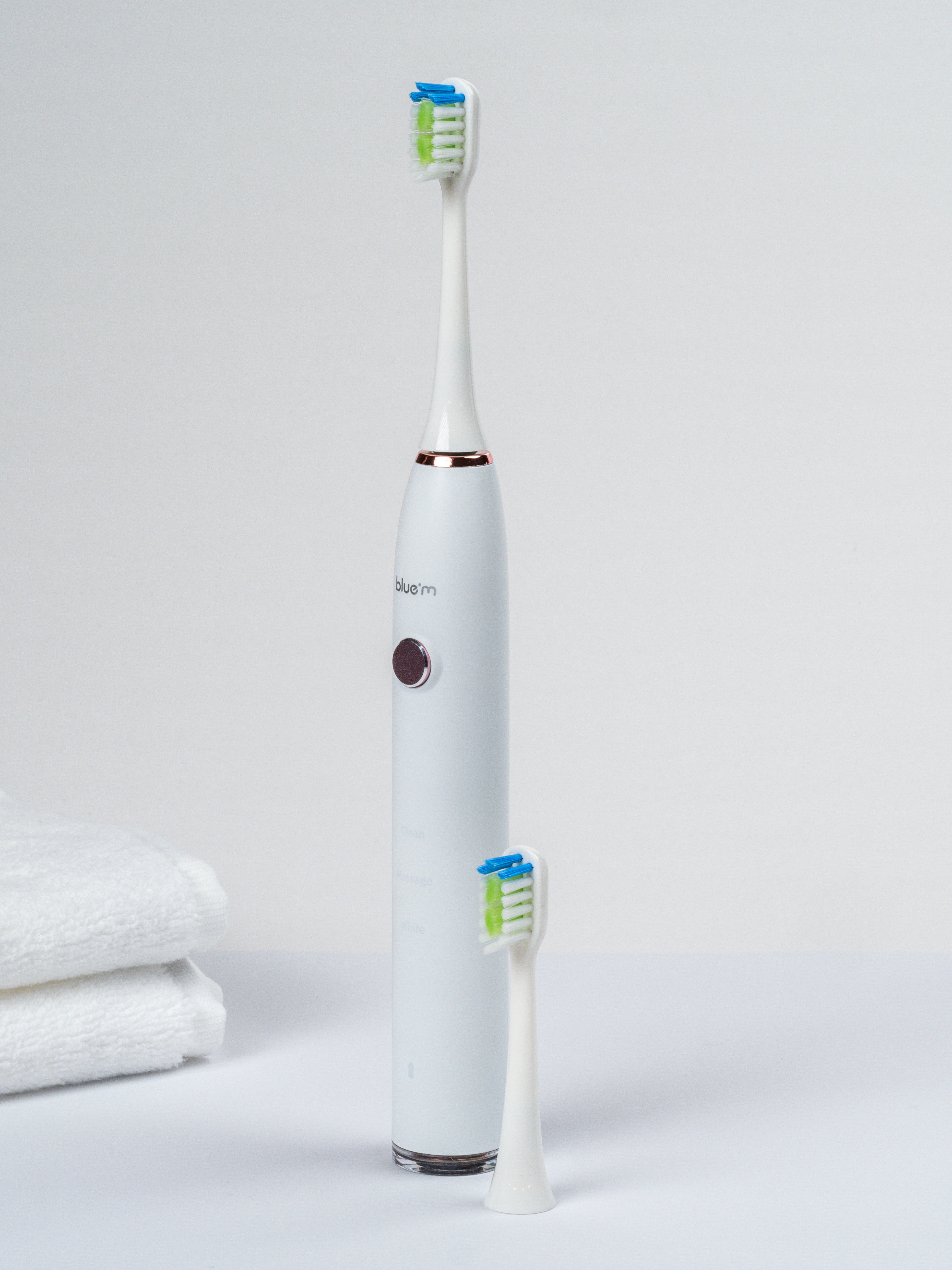 Elektrische Schallzahnbürste mit Ersatz-Bürstenkopf im Vordergrund