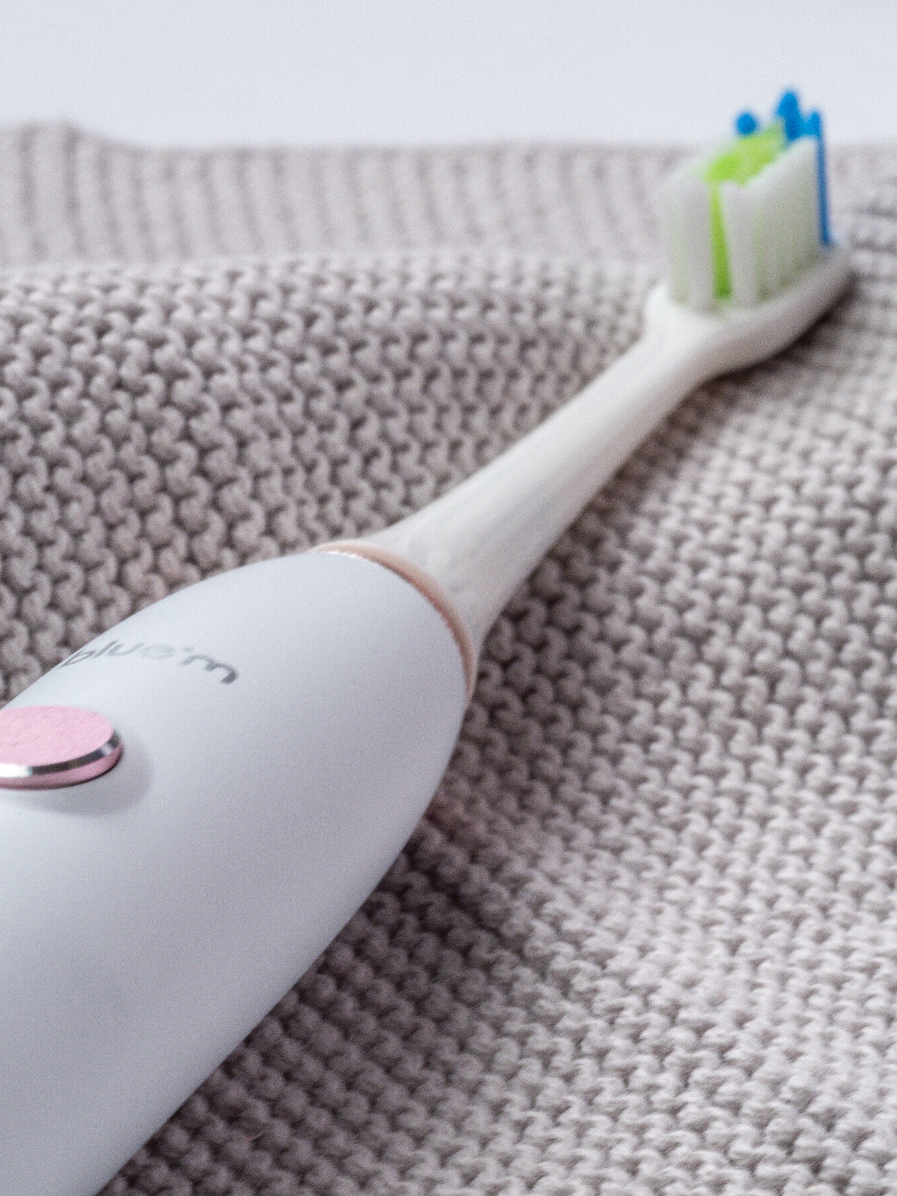 Elektrische Schallzahnbürste auf einem hellgrauen Handtuch