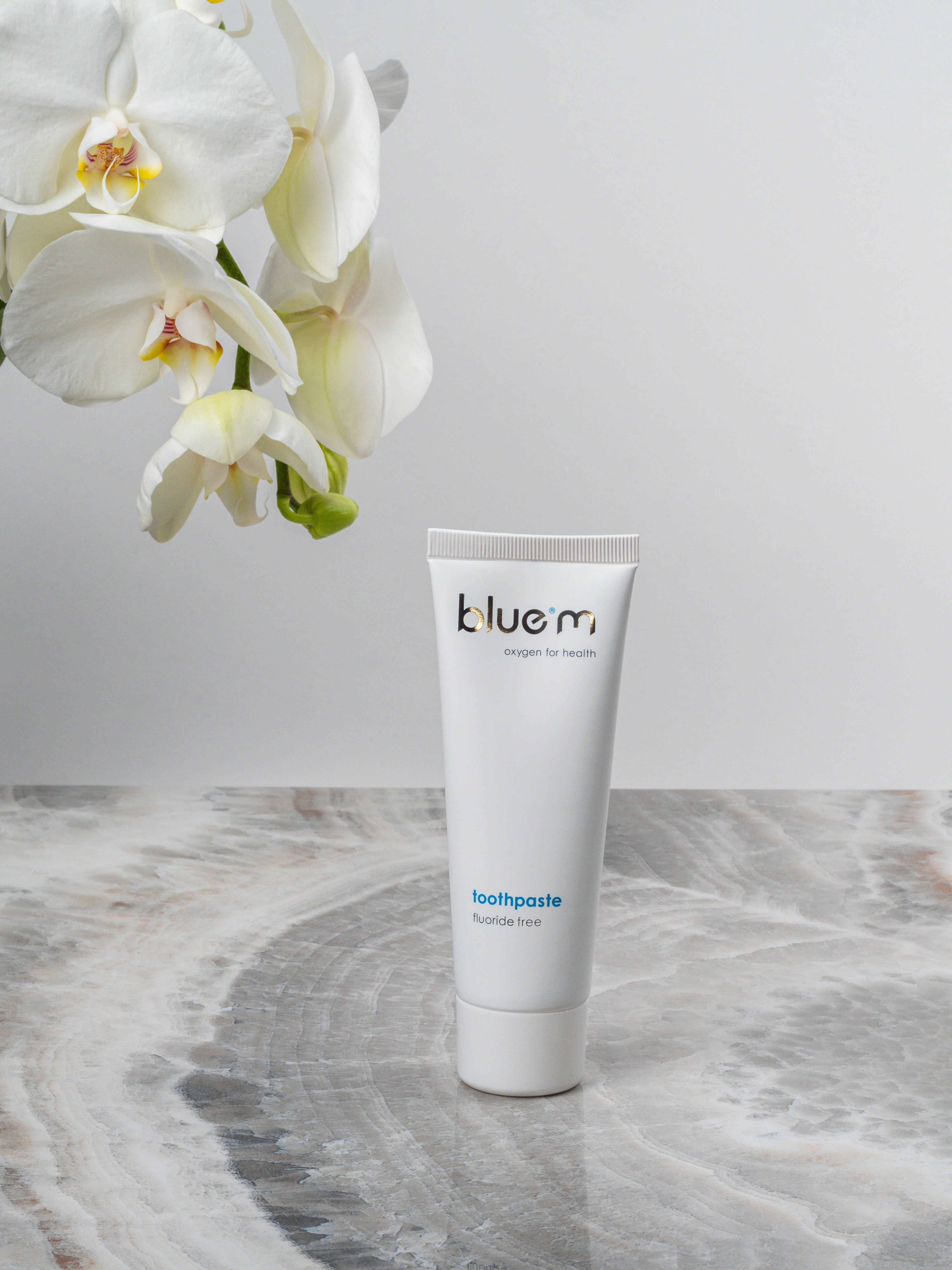 Eine Tube Zahngel ohne Fluorid steht auf einer grauen Oberfläche