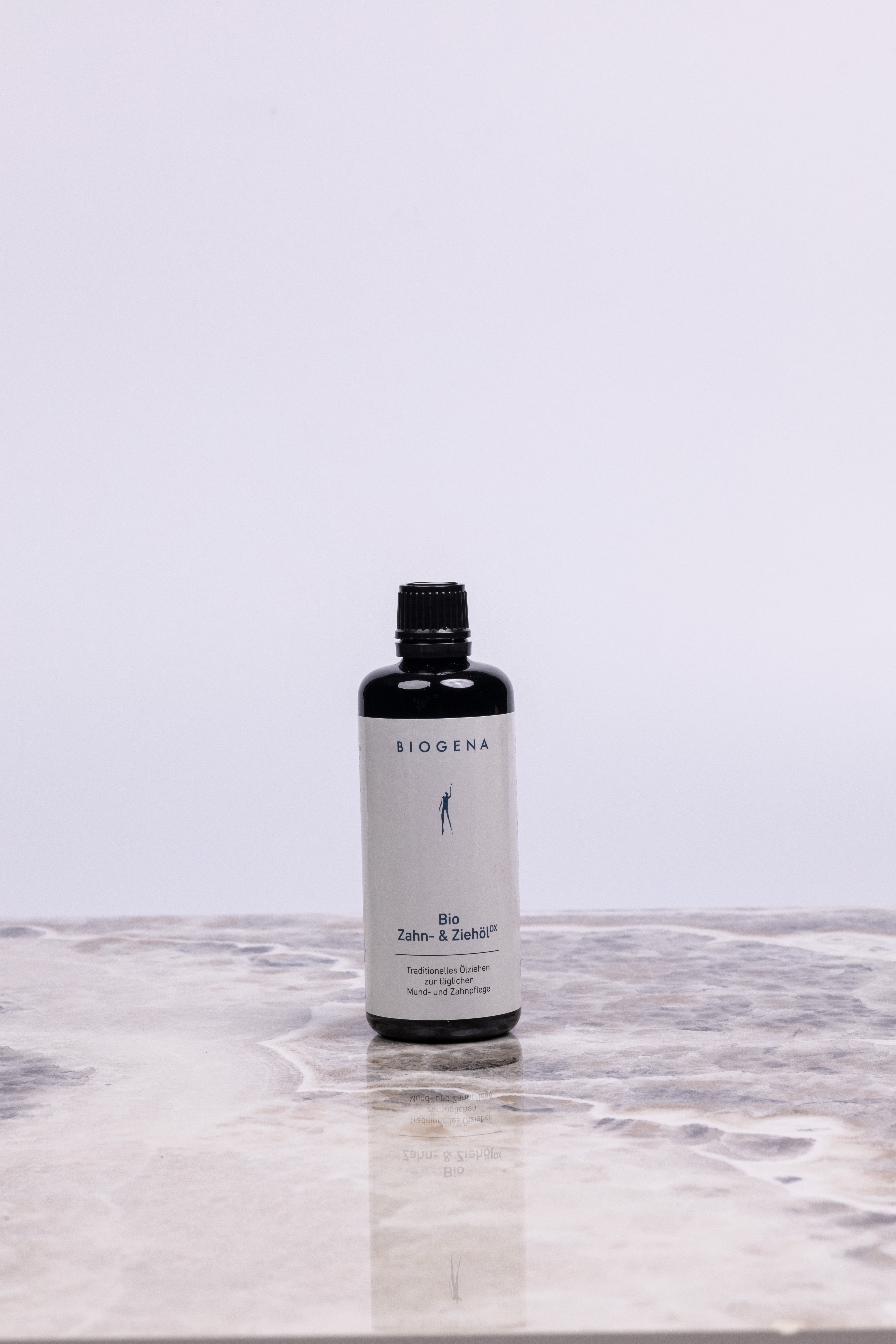 BIOGENA Zahn- und Ziehöl Flasche steht auf einer Marmorplatte.