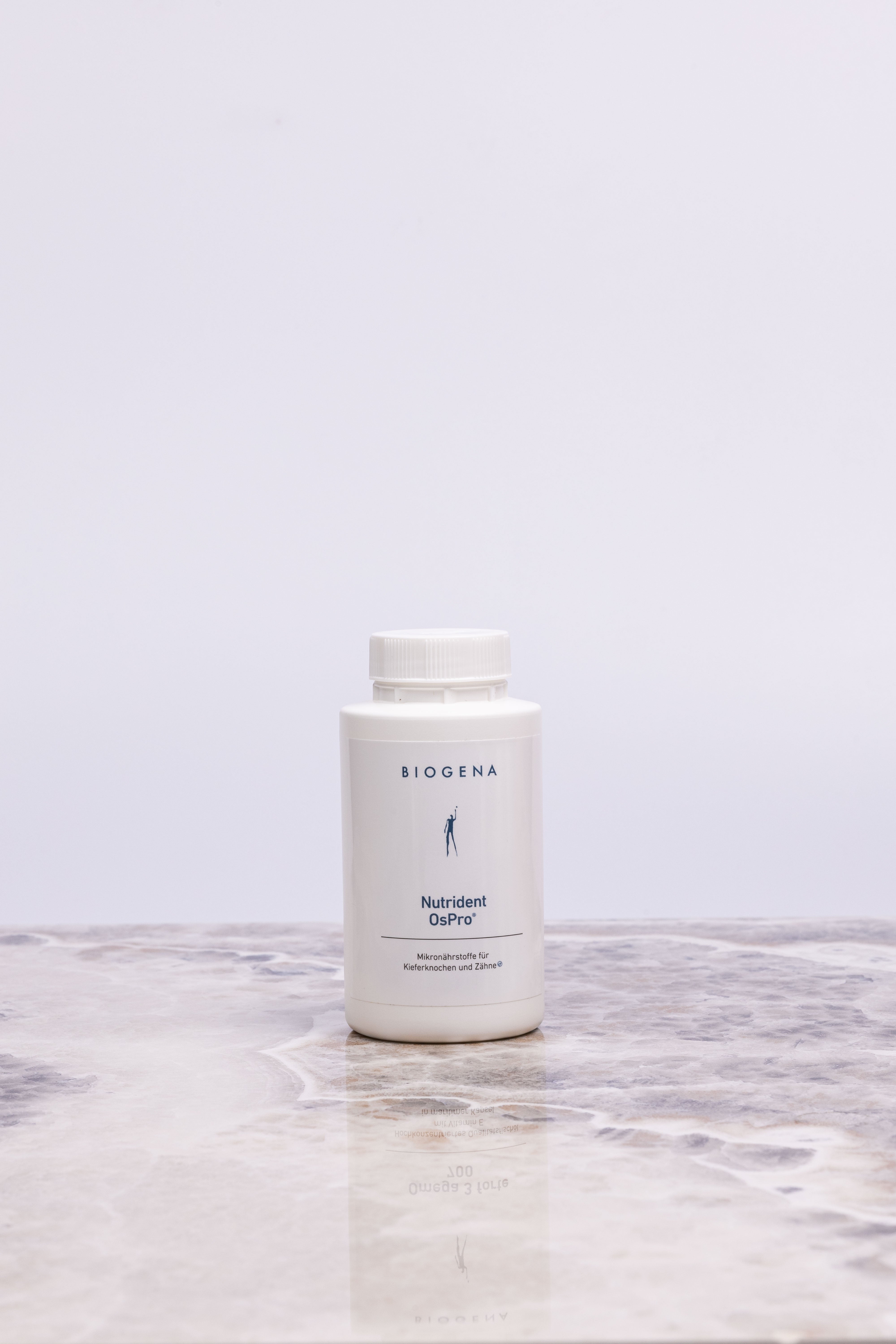 Geschlossene Verpackungsdose Biogena Nutrident OsPro steht auf einer Marmorplatte.
