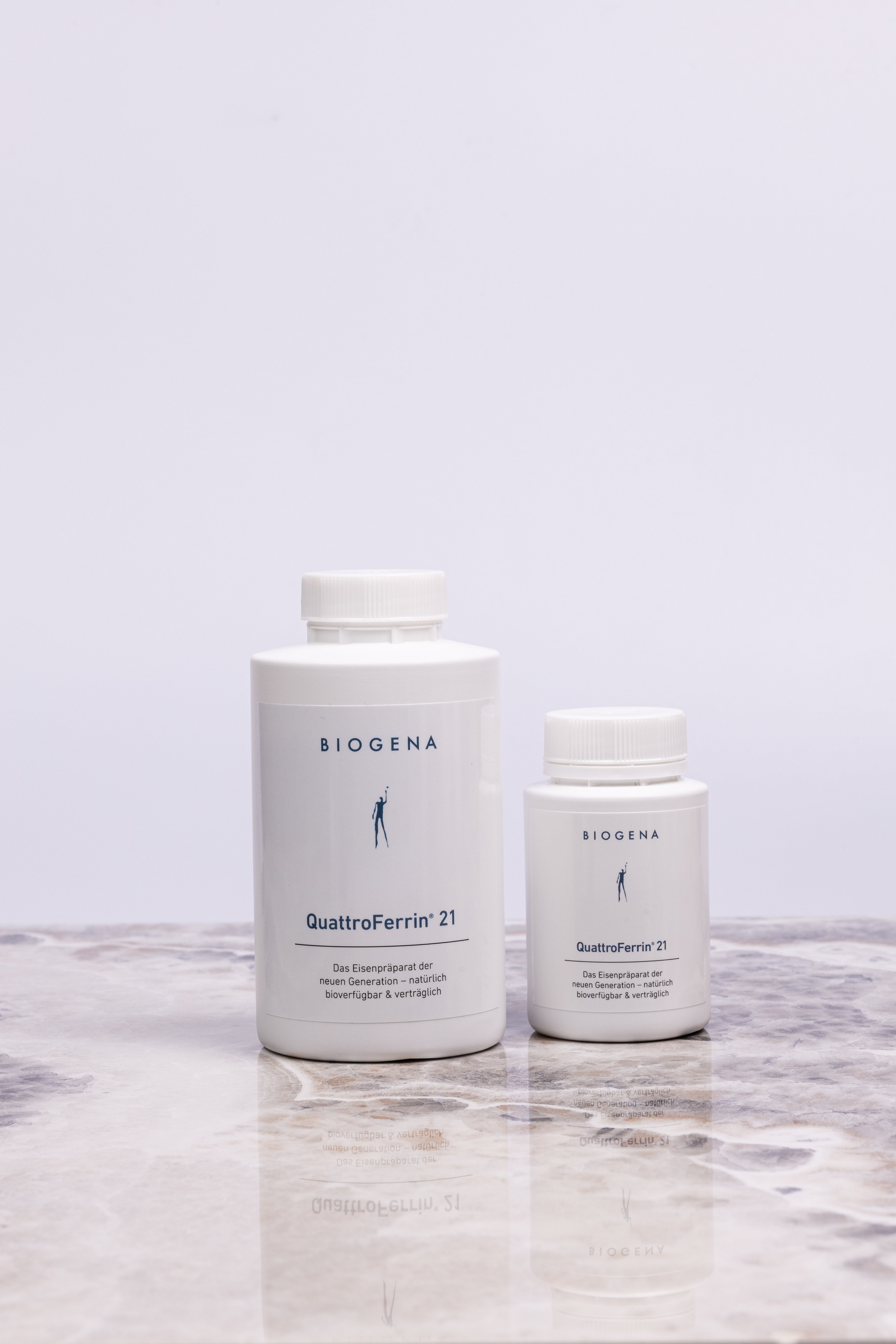 Zwei Dosen QuattroFerrin 21 unterschiedlicher Verpackungsgrößen stehen auf einer Marmorplatte.