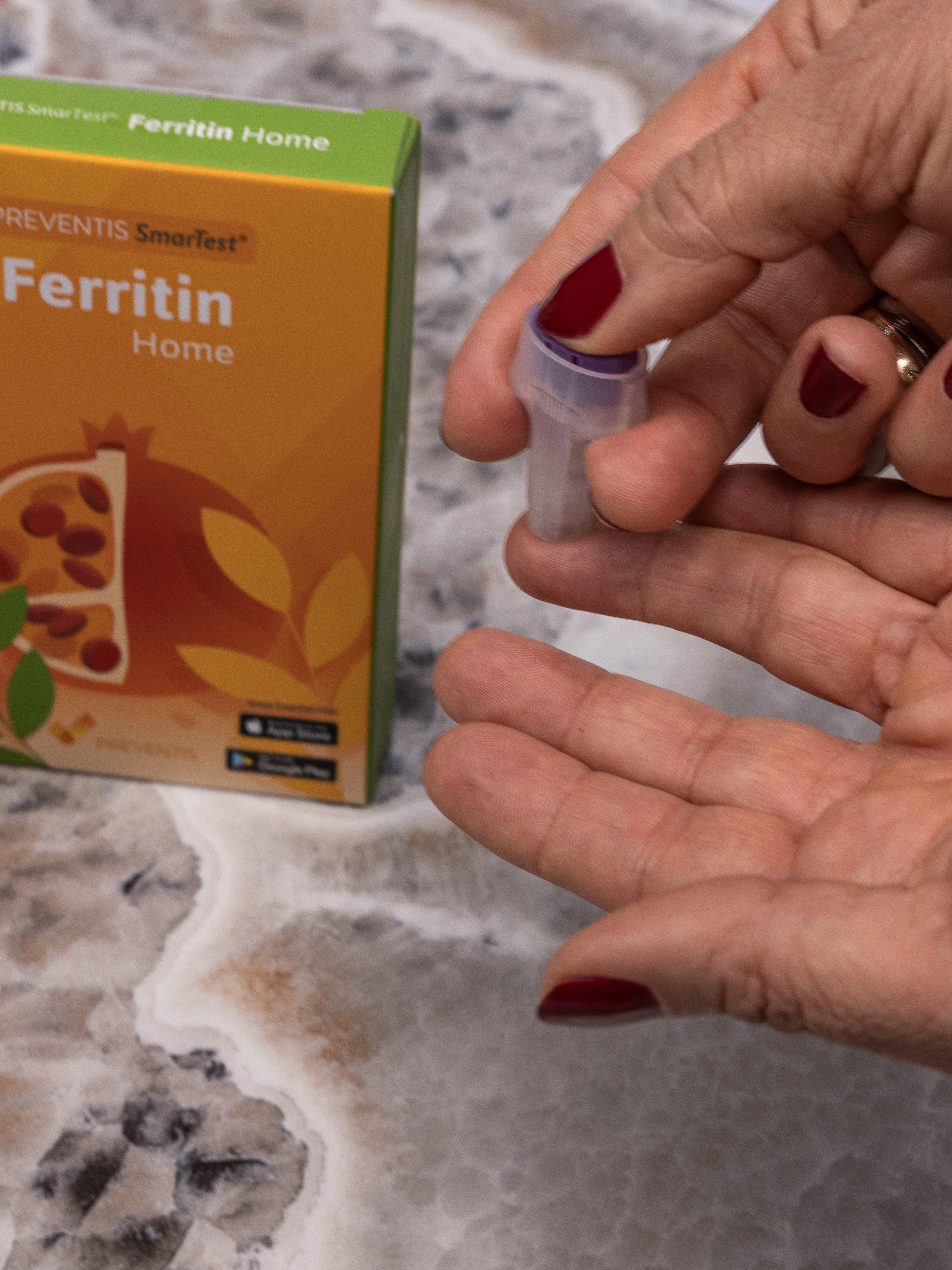 Darstellung des Testvorgang des Ferritin Schnelltests, dabei sind zwei Frauenhände zu sehen. Eine Hand nutzt  die spezielle Stechhilfe, um in die Fingerkuppe des Mittelfingers der anderen Hand zu stechen.